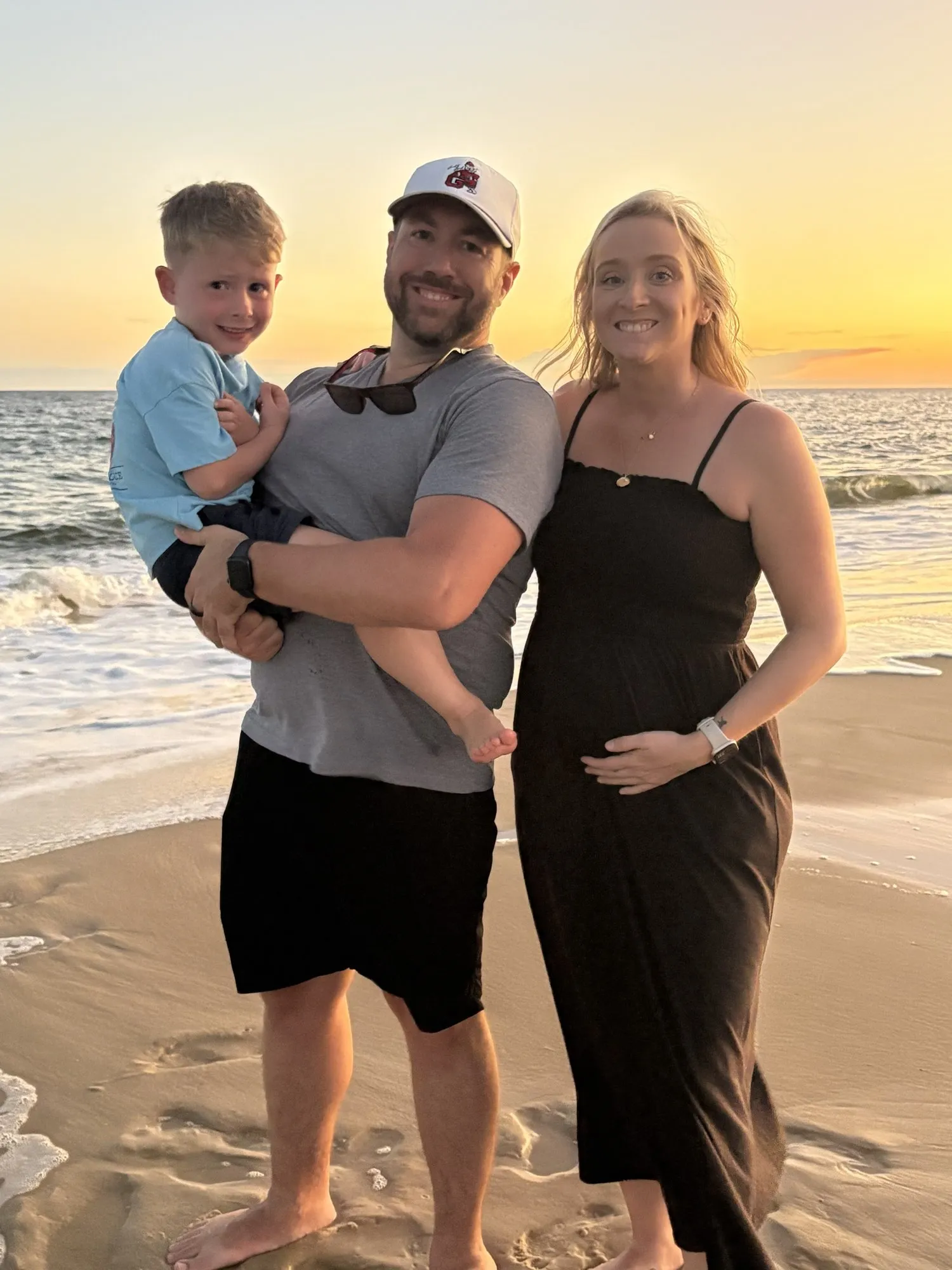 Samantha, Chris, and their son on the beach at sunset